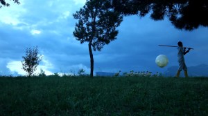 Sunset. A line of white geese follow a woman carrying a large moon slung on a stick over her shoulder