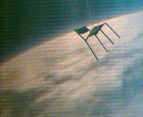 escape6d A chair floats above the Earth against the blackness of space