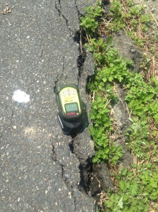 Geiger counter placed on a crack in the road
