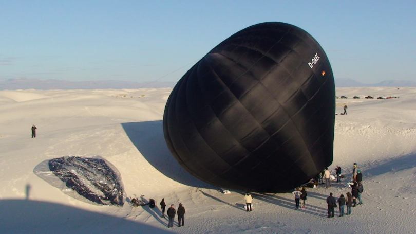 Black balloon lying in desert